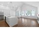 Bright, open-concept living room with vaulted ceilings, wood floors, and a modern kitchen island at 308 Chardonnay Way, Woodstock, GA 30188