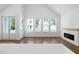 Bright open-concept living room with wood floors and fireplace and multiple windows at 308 Chardonnay Way, Woodstock, GA 30188
