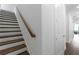 Stairway with wooden handrail and white risers near a hallway with modern doors at 308 Chardonnay Way, Woodstock, GA 30188