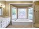 Bright bathroom features a soaking tub under windows and a glass enclosed shower at 3761 Bays Ferry Way, Marietta, GA 30062