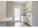 Well-lit laundry room with modern finishes, window, and built-in shelving at 3761 Bays Ferry Way, Marietta, GA 30062