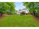 Large backyard featuring green lawn, mature trees, and a deck at 1008 Stream Valley Ct, Alpharetta, GA 30022