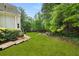 View of the expansive backyard showing mature trees and lush lawn at 1008 Stream Valley Ct, Alpharetta, GA 30022