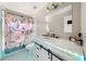 Bright bathroom features a vanity with LED lighting, marble countertop, and a tub with a floral shower curtain at 1008 Stream Valley Ct, Alpharetta, GA 30022