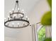 Stylish, modern chandelier hangs above a window with view to the lush greenery outside at 1008 Stream Valley Ct, Alpharetta, GA 30022
