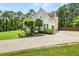 View of the side of the home showcasing a driveway and manicured landscaping at 1008 Stream Valley Ct, Alpharetta, GA 30022