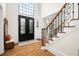Grand foyer with hardwood floors, staircase with wrought iron railings, and a view of the front door at 1008 Stream Valley Ct, Alpharetta, GA 30022