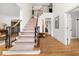 Spacious foyer featuring wood floors, staircase with rod iron, and view into other rooms at 1008 Stream Valley Ct, Alpharetta, GA 30022
