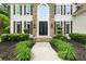 Elegant front entrance featuring a stone facade, arched window, and wrought iron double doors at 1008 Stream Valley Ct, Alpharetta, GA 30022