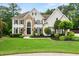 Charming two-story home featuring stone accents, a well-manicured lawn, and lush landscaping at 1008 Stream Valley Ct, Alpharetta, GA 30022