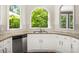 Kitchen sink and stainless dishwasher with views to the wooded backyard at 1008 Stream Valley Ct, Alpharetta, GA 30022
