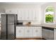 Well-equipped kitchen features stainless appliances, granite countertops, and white cabinets for storage at 1008 Stream Valley Ct, Alpharetta, GA 30022