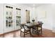 Bright dining area with french doors to balcony, hardwood floors, and modern table set at 1032 Robert Smalls Way, Atlanta, GA 30318