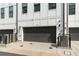 Modern townhome featuring a gray garage door, white exterior, and sleek black framed windows at 1032 Robert Smalls Way, Atlanta, GA 30318