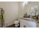 Powder room with a granite countertop, white vanity, and modern fixtures at 10610 Kingsmark Trl, Alpharetta, GA 30022
