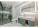 Modern bathroom with walk-in shower, illuminated mirror, and vanity with stylish green cabinetry at 10610 Kingsmark Trl, Alpharetta, GA 30022