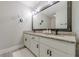 Modern bathroom features a double sink vanity with granite countertops and a large framed mirror at 10610 Kingsmark Trl, Alpharetta, GA 30022