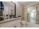 Updated bathroom featuring a granite countertop and a tub with glass doors at 10610 Kingsmark Trl, Alpharetta, GA 30022