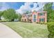 Beautiful home with a spacious lawn, manicured shrubbery, and mature trees, creating an inviting curb appeal at 10610 Kingsmark Trl, Alpharetta, GA 30022