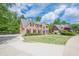 Gorgeous brick home with a sprawling lawn, mature trees, and another home in view, creating a pleasant streetscape at 10610 Kingsmark Trl, Alpharetta, GA 30022