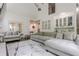 Bright living room featuring vaulted ceilings, hardwood floors, wet bar, and a large sectional sofa at 10610 Kingsmark Trl, Alpharetta, GA 30022