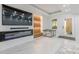 Modern living room featuring electric fireplace, television, marble floors, and bright outdoor views at 10610 Kingsmark Trl, Alpharetta, GA 30022