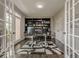 Office space featuring a sleek desk and a large, custom bookcase, entered through French doors at 10610 Kingsmark Trl, Alpharetta, GA 30022