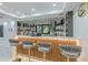 Bright wet bar with custom lighting, open shelving, counter seating and outdoor views at 10610 Kingsmark Trl, Alpharetta, GA 30022