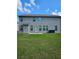 Backyard with green lawn and neutral siding on the two-story home at 221 Eleanora Way, Loganville, GA 30052