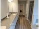 Well-lit bathroom featuring a double vanity, hardwood floors, and a glass-enclosed shower at 221 Eleanora Way, Loganville, GA 30052