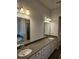 Bathroom with double sinks, modern fixtures, and a large mirror, offering ample space at 221 Eleanora Way, Loganville, GA 30052