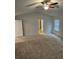 Bedroom with ceiling fan, neutral walls, and carpeted floor, leading to a hallway at 221 Eleanora Way, Loganville, GA 30052