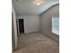 Vaulted bedroom featuring neutral carpeting, large window, and walk in closet at 221 Eleanora Way, Loganville, GA 30052