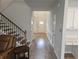 Inviting hallway with hardwood floors, a staircase, and a cozy seating area at 221 Eleanora Way, Loganville, GA 30052