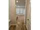 Hallway with wood-look floors leads to open kitchen and living area filled with natural light at 221 Eleanora Way, Loganville, GA 30052