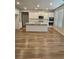 Open-concept kitchen featuring white cabinets, stainless steel appliances, and a large center island at 221 Eleanora Way, Loganville, GA 30052