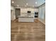 Open kitchen with stainless appliances, white cabinetry, and large center island at 221 Eleanora Way, Loganville, GA 30052