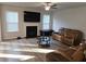 Cozy living room with a fireplace, comfortable seating, and a ceiling fan at 221 Eleanora Way, Loganville, GA 30052