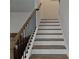 Elegant staircase with wooden treads, white risers, and a black metal railing at 221 Eleanora Way, Loganville, GA 30052