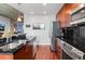 Modern kitchen with stainless steel appliances, black backsplash, and wooden cabinetry, adjacent to the dining area at 250 Pharr Ne Rd # 1914, Atlanta, GA 30305