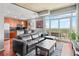 Modern condo living room with black leather sectional, wood floors, and a balcony overlooking a cityscape at 250 Pharr Ne Rd # 1914, Atlanta, GA 30305
