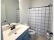 Bright bathroom features a blue vanity and stylish black and white patterned shower curtain at 4487 Kerrington Ave, Sugar Hill, GA 30518
