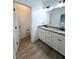 Elegant bathroom boasts double sinks, granite countertops, and wood-look tile flooring at 4487 Kerrington Ave, Sugar Hill, GA 30518