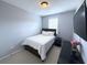 Cozy bedroom with neutral walls and carpet and a dark wood bed frame and dresser at 4487 Kerrington Ave, Sugar Hill, GA 30518