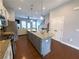 Open-concept kitchen boasts granite countertops, stainless appliances, and a central island with bar stools at 4487 Kerrington Ave, Sugar Hill, GA 30518