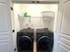 The laundry room has a side by side washer and dryer with shelving above at 4487 Kerrington Ave, Sugar Hill, GA 30518