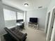 Bright office with a sofa, a TV, and an open window at 4487 Kerrington Ave, Sugar Hill, GA 30518