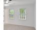 Bright bedroom featuring two windows, neutral carpet, and a ceiling fan at 4536 Mountain Creek Ne Dr, Roswell, GA 30075