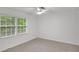 Bright bedroom with neutral carpet, ceiling fan, and windows at 4536 Mountain Creek Ne Dr, Roswell, GA 30075
