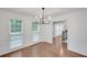 Bright dining room with hardwood floors, white trim, and a modern chandelier, illuminated by natural light through large windows at 4536 Mountain Creek Ne Dr, Roswell, GA 30075